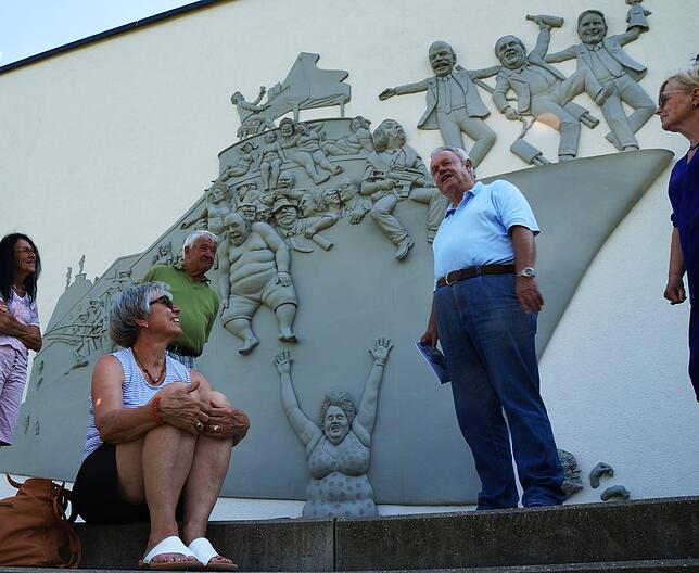Klaus Meckelburg (Mitte) erklärt das Narrenschiff an der Außenwand des Seeums in Bodman.