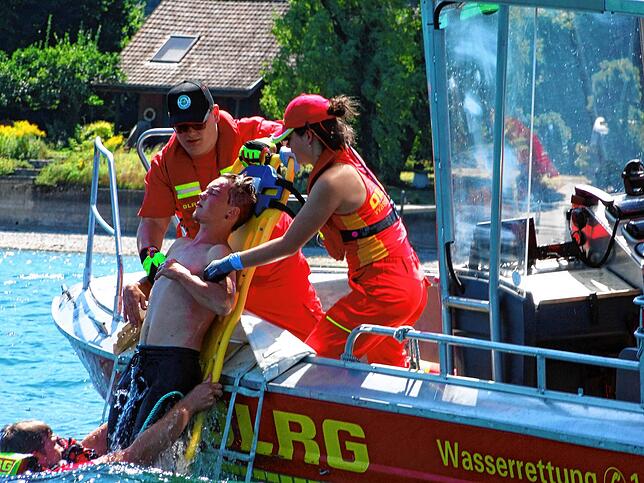 Der verletzte Wassersportler wird bei der DLRG-Schauübung über ein Spine-Board rückenschonend auf das Rettungsboot gehieft (von links): ...