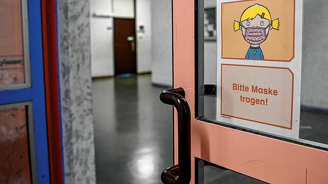 Schild mir der Aufschrift &bdquo;Bitte Maske tragen!&ldquo;.