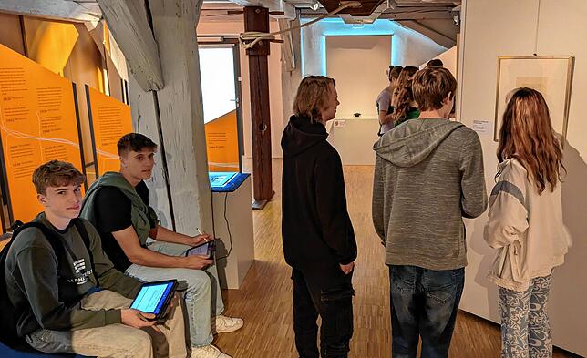 Die Schüler schauen sich die Bilder an und machen sich auf ihren Tablet-PCs Notizen.
