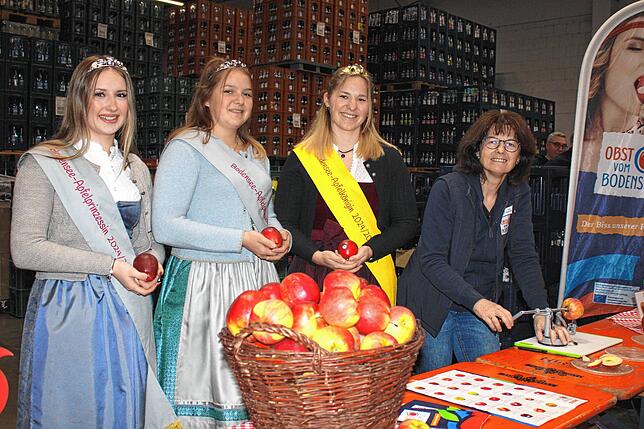 Beim Stand des Bodenseeobstes präsentieren sich die Apfelprinzessin Marlene Löhle (von links) mit Königin Emelie Witzigmann und ...