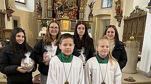 Die Ministrantinnen Lorena Cormaci, Frieda Dörflinger, Carmen Schuler und Lucia Schmidt (hinten v.l.) halten ihr Abschiedsgeschenk in ...