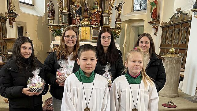 Die Ministrantinnen Lorena Cormaci, Frieda Dörflinger, Carmen Schuler und Lucia Schmidt (hinten v.l.) halten ihr Abschiedsgeschenk in ...
