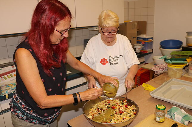Sabine Gähme und Monika Fink mischen den mediterranen Nudelsalat.