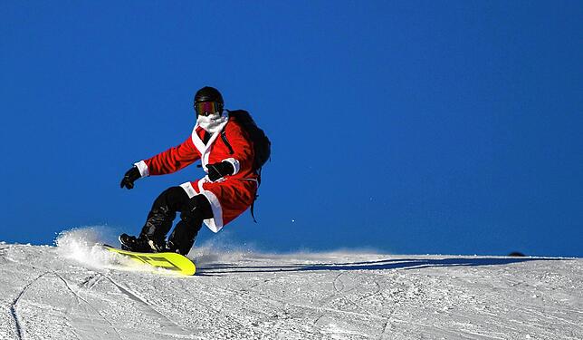 Ein als Weihnachtsmann verkleideter Snowboarder fährt im Dezember 2019 zum Beginn der Skisaison den Feldberg herab.