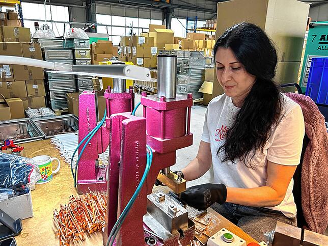 Karine Bayanduryan an ihrem Arbeitsplatz. Genauigkeit und Qualitätsbewusstsein sind besonders wichtig: Durch die Kupferteile fließt Strom.