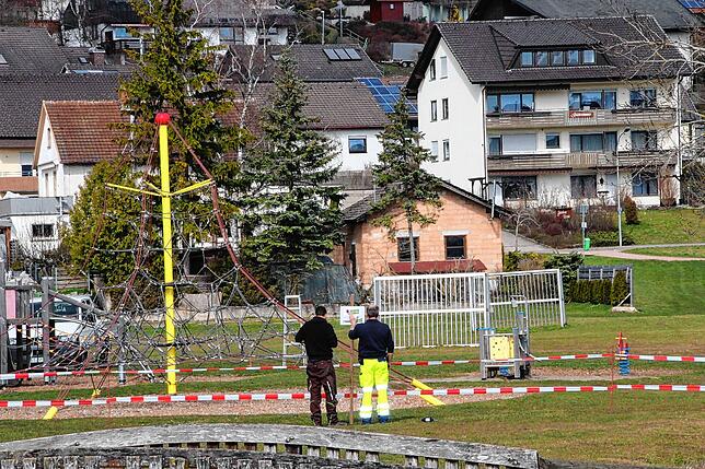 Mitarbeiter des städtischen Bauhofs sperren die Spielplätze ab, hier den Platz in der Weihergrube.