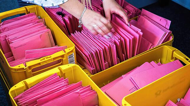 Eine Frau steckt einen Wahlbrief für die Bundestagswahl in einen Postkasten. Für die Auszählung der Briefwahlstimmen braucht es ...