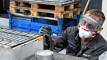 Hier kommt die Trennschleifmaschine zum Einsatz: Ein Primobius-Mitarbeiter sägt ein Batteriegehäuse auf.