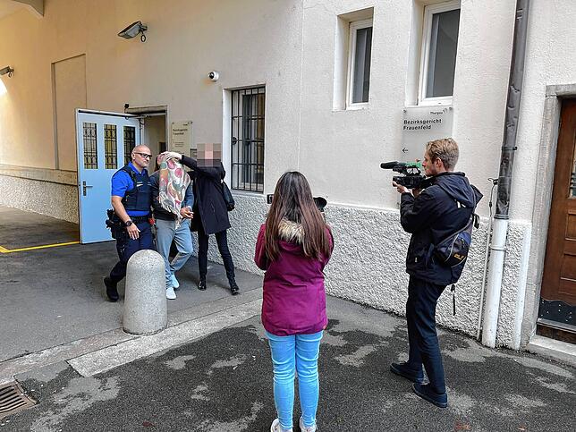 Seine Verteidigerin verbirgt das Gesicht des Beschuldigten mit ihrem Schal, als er aus dem Bezirksgericht Frauenfeld geführt wird.