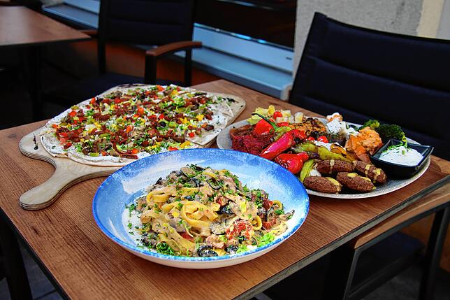 Vegan und vegetarisch auf der Karte bei Sirin‘s: Flammkuchen, Pasta Mediterran und Antipasti-Teller mit Falafel.