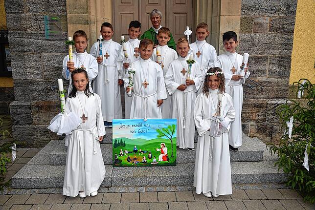 Nach dem festlichen Gottesdienst stellten sich die Kommunionskinder mit Pater Matthias Hanisch zum Gruppenfoto vor der Kirche in Berau ...