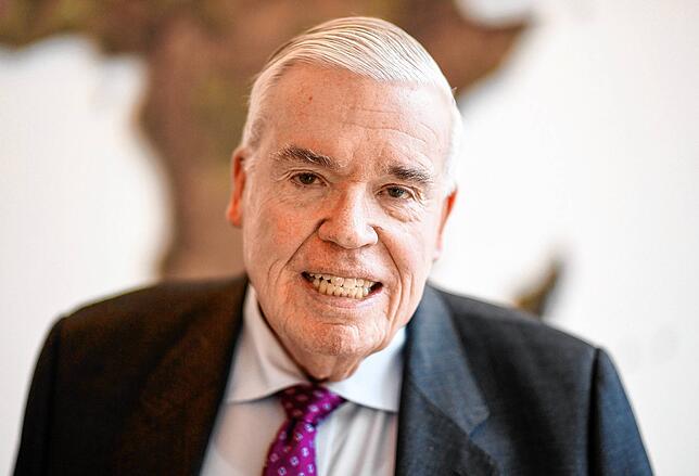Klaus-Michael Kühne, Unternehmer, steht im Hauptsitz der Kühne und Nagel AG vor einer Weltkarte.