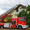 Eine Drehleiter steht vor dem Brandhaus. Oberhalb der Balkontüre hat das Feuer deutliche Rußspuren hinterlassen.