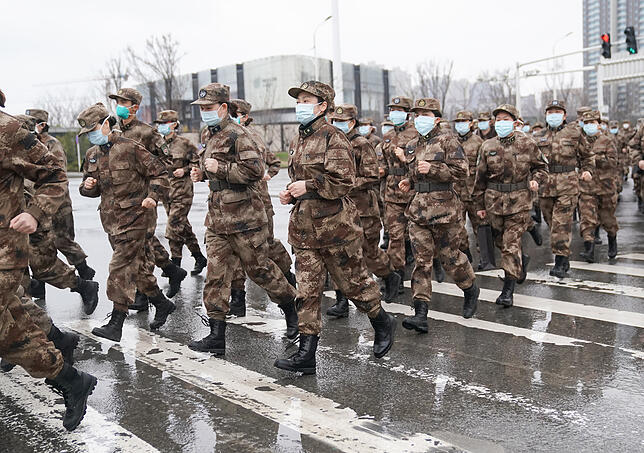 Mitglieder des medizinischen Teams des chinesischen Militärs, die für das Wuhan Jinyintan Krankenhaus im Einsatz sind, gehen gesammelt ...