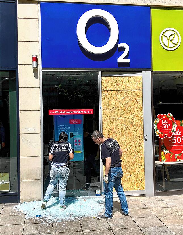 Polizeibeamte sichern Spuren vor einem beschädigten Geschäft in der Stuttgarter Innenstadt.