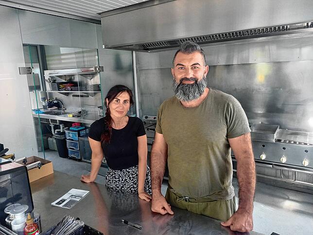 Neben Currywurst stehen unter anderem auch Köfte, Cevapcici und Burger auf der Speisekarte: Zeliha und Talip Caliskan warten auf Gäste.