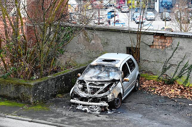 Ein Auto auf einem Parkplatz am Stadtwall ist ausgebrannt. Seither steht es dort und hat noch Absperrband bekommen.