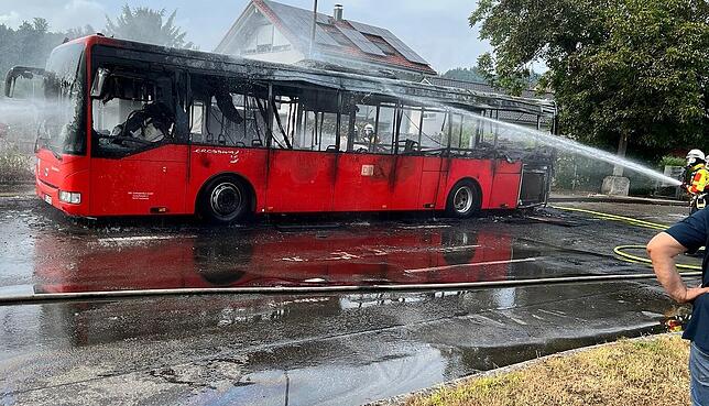 Feuerwehrmänner löschen den Linienbus, der vermutlich wegen eines technischen Defekts am Donnerstagabend in Dogern ausbrannte.