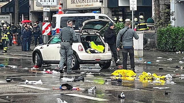 Polizisten untersuchen ein Auto in der Nähe des Einsatzortes in München.