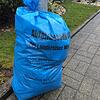 Ein blauer Sack der Abfallwirtschaft des Landkreises Waldshut steht an einer Straße und wartet auf die Abholung.