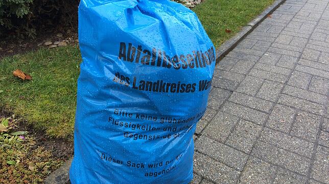 Ein blauer Sack der Abfallwirtschaft des Landkreises Waldshut steht an einer Straße und wartet auf die Abholung.