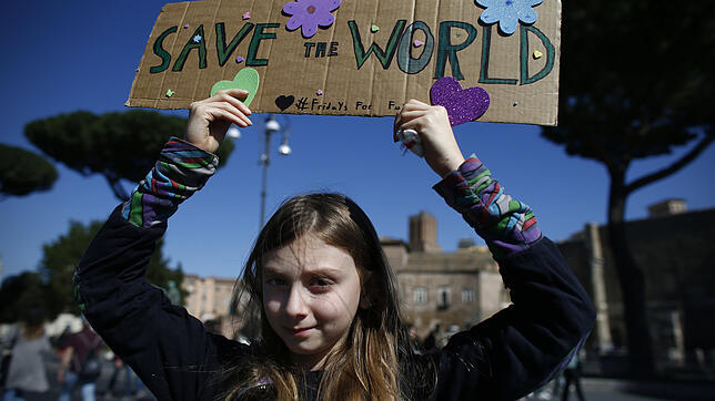 Die Schülerin Alice hält in Rom bei einer "Fridays for Future"-Klimademonstration ein Schild mit der Aufschrift "Rettet die Welt" in ...