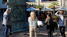 Ein Stadtführer erklärt Gästen die von Klaus Ringwald geschaffene Stele auf dem Rudolf-Eberle-Platz. 300 Stadtführungen werden aktuell ...