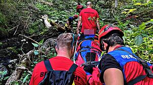 Mit einer Gebirgstrage retten Mitglieder der Bergwacht eine verletzte Wanderin aus der Rötenbachschlucht.