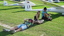 Die jungen Fliegerinnen und Flieger suchen in kleinen Gruppen Schatten unter den Flügeln ihrer Flugzeuge, während sie darauf hoffen, ...