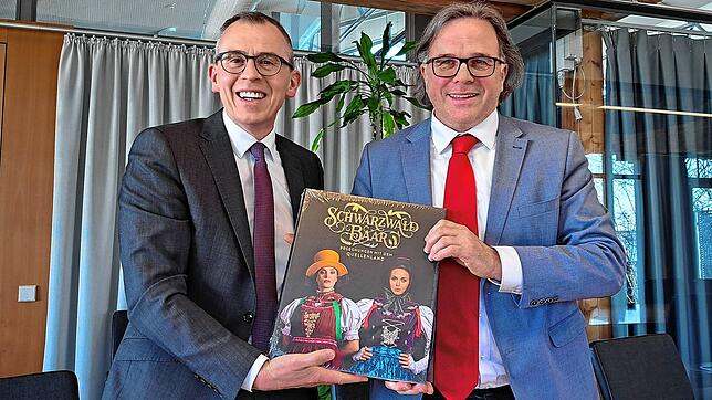 Landrat Sven Hinterseh (links) überreicht Regierungspräsiden Carsten Gabbert einen prächtigen Bildband mit Motiven aus dem Landkreis.