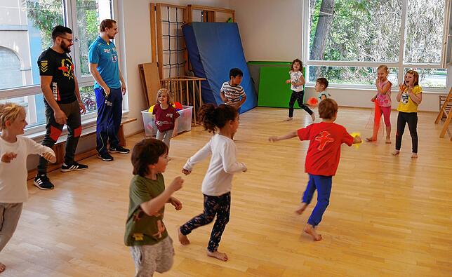 Erzieher Amin Hilali vom Kinderhaus am Rhein (links) und HSG-Trainer Kai Mittendorf lassen die Sportgarten-Kinder „Zauberer und ...