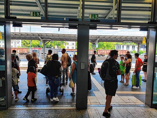 Fahrgäste warten in diesem Bild aus dem August auf ihre Züge, während die Polizei einen verwaisten Koffer vor dem Bahnhof beim Busstopp ...