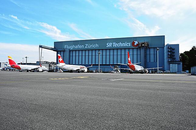 Im Hangar warten Mitarbeiter Flugzeuge und machen sie wieder startklar.