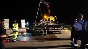 Einsatzkräfte bereiten den Abtransport eines Unfallfahrzeugs vor.