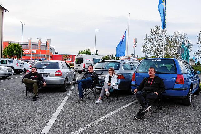 Die Fahrzeugliebhaber machen es sich auf Campingstühlen gemütlich und beobachten das Schauspiel.