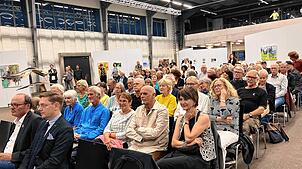 Etliche Besucher und Besucherinnen finden sich zur feierlichen Eröffnung der Jahresausstellung der Künstlergilde mit dem Namen ...