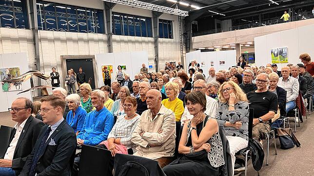 Etliche Besucher und Besucherinnen finden sich zur feierlichen Eröffnung der Jahresausstellung der Künstlergilde mit dem Namen ...
