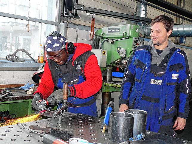Abdoulie Ceesay aus Gambia bei der Arbeit in der Schlosserei, rechts sein Kollege und Junior-Chef Fabian Menge.