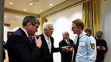 Dann eben ins Polizeipräsidium: Ministerpräsident Winfried Kretschmann (Mitte) unterhält sich anstelle eines Ausstellungsbesuchs mit dem ...
