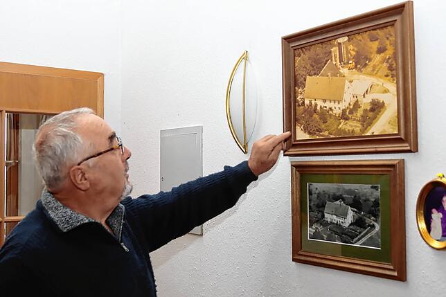 Berthold Hettich zeigt Aufnahmen des Hofes am Ortsrand von Kirchdorf, wo das Kreuz früher stand.