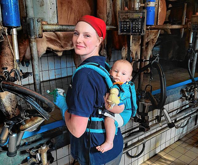 Astrid Walter mit Sohn Arne. Die Babytrage hängt im Stall bereit, falls sie ihren Sohn bei der Arbeit mitnehmen will.