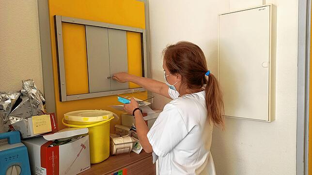 Ärztin Eva-Maria Neurohr holt den Impfstoff aus dem Übergabefach des Labors.