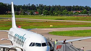 Fluggäste verlassen eine Maschine in Friedrichshafen. Könnte der Bodensee-Airport künftig vermehrt militärisch genutzt werden?