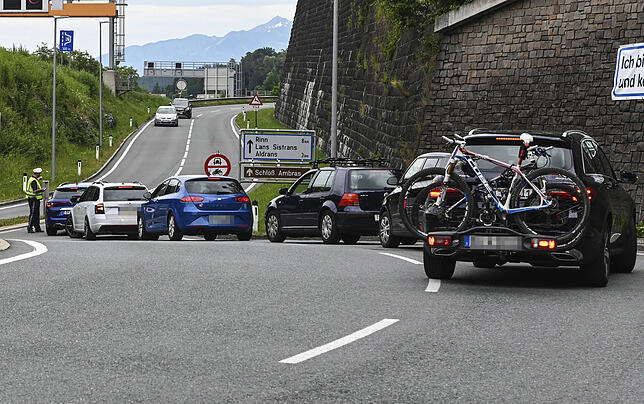 Ein Polizist hält Autos vor einer Autobahnauffahrt an.