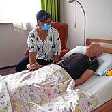 Hospiz-Leiterin Silke Uhl sitzt am Bett eines „Gastes“. So werden die Patienten im Hospiz genannt.