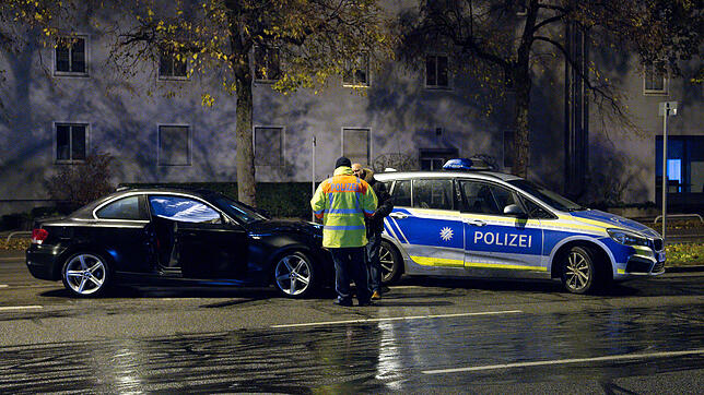 Beamte untersuchen in der Fürstenrieder Straße in München das Auto des Rasers (links).