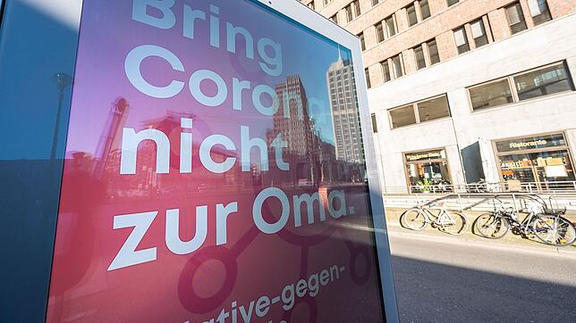 Auf einer Anzeigetafel am Potsdamer Platz in Berlin steht "Bring Corona nicht zur Oma"