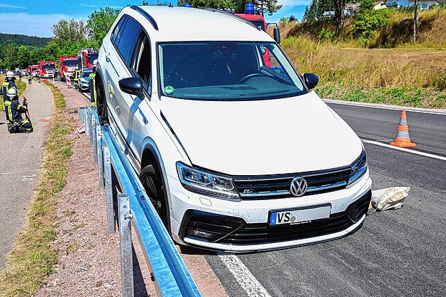 Das Auto steht mit einem Hinterrad auf der Leitplanke, mit den Vorderrädern auf der Straße.