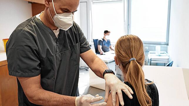 Ein zwölfjähriges Mädchen wird in einer Arztpraxis vom Hausarzt mit dem Serum von Biontech/Pfizer geimpft.